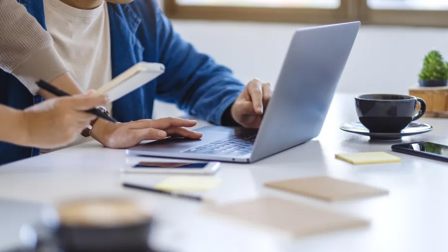Ein Frau und ein Mann arbeiten gemeinsam an einem Laptop 